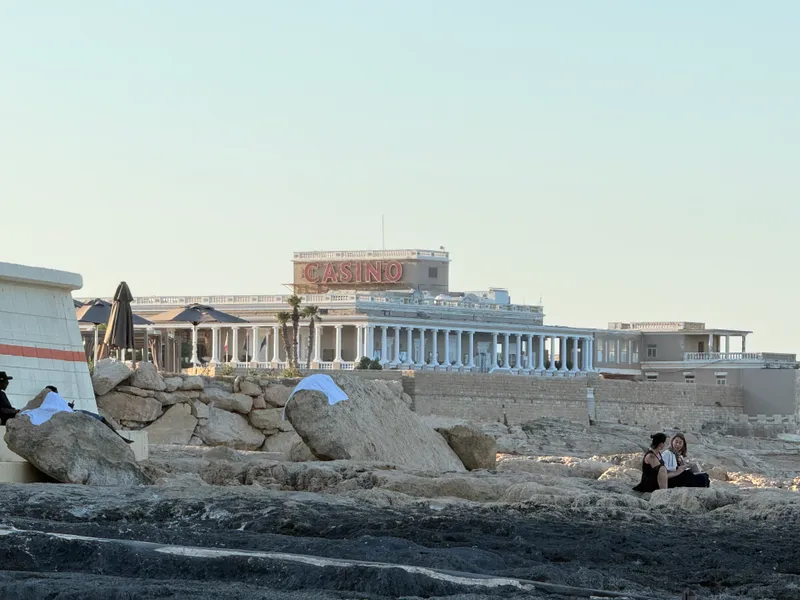 The quieter end of a St Julian's night: the Dragonara Casino on its headland at dusk, seen from the St George's Bay rocks