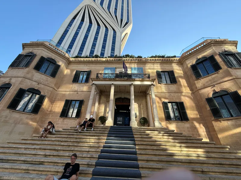 The whole Paceville story in one frame: the 1903 Mercury House, now the Museum of Illusions, with the Mercury Tower rising directly behind it