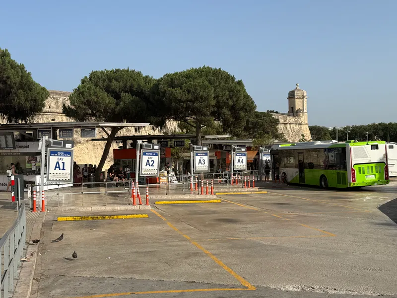 The Valletta terminus at Triton Fountain, where most of the network starts and ends. Bays are lettered, and the app tells you which one before the sign does.